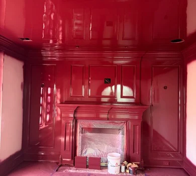 High-gloss red paneled library with fireplace surround finished by United Painting