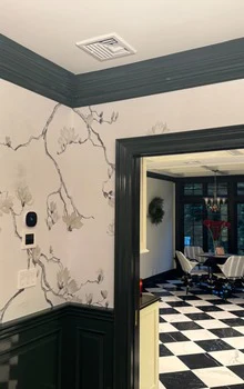 Branch-pattern mural above deep green painted wainscoting