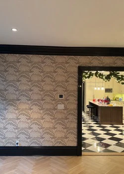 Patterned wallcovering hallway with dark trim and checkered floor