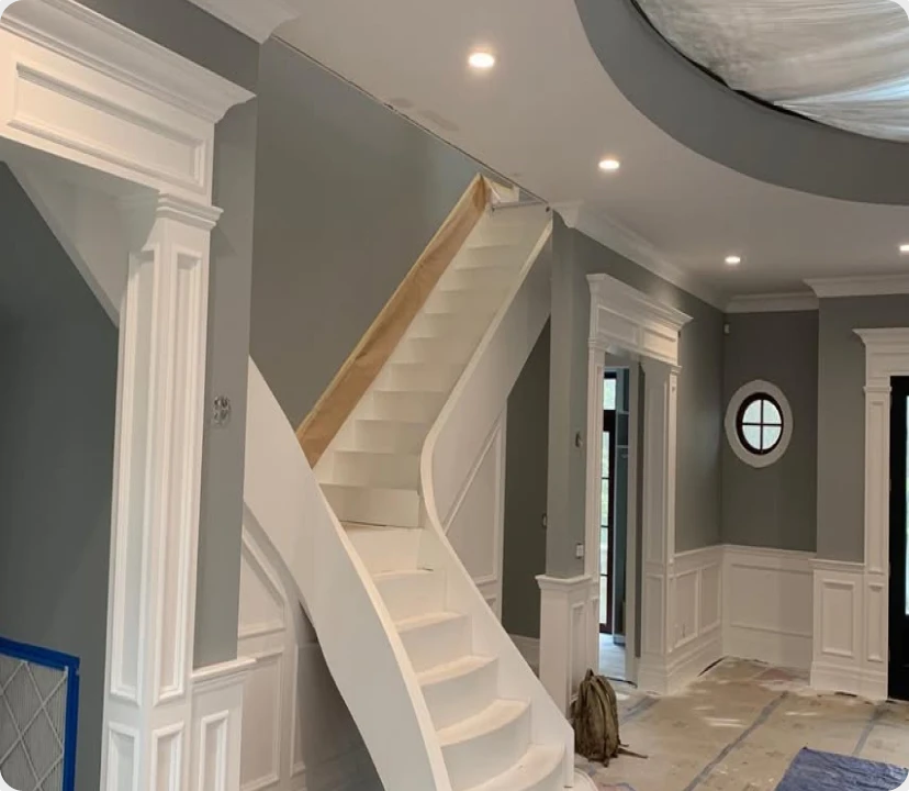 Two-story staircase and millwork painted by United Painting